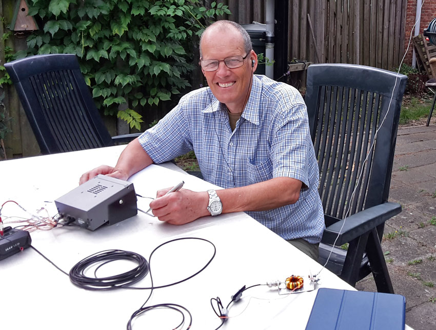 Gerard ZL2GVA operating a K1 transceiver sitting at a table outdoors