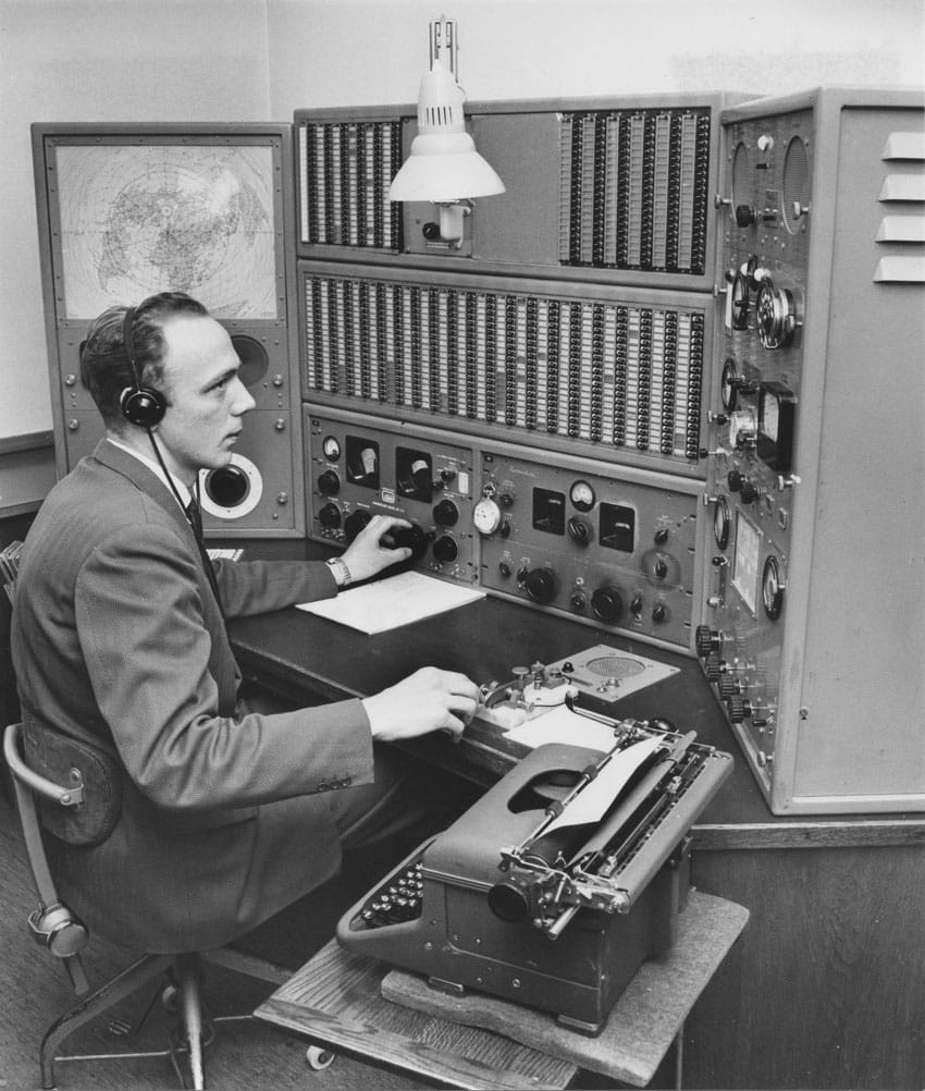 Operator with Morse key and two Hammarlund receivers at SAG Goteborg Radio, c1960