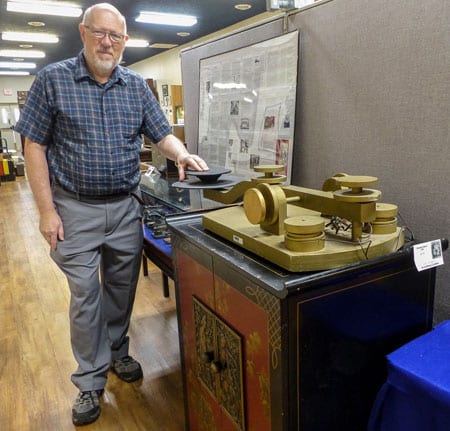 Man posing with very large straight key, part of a museum display